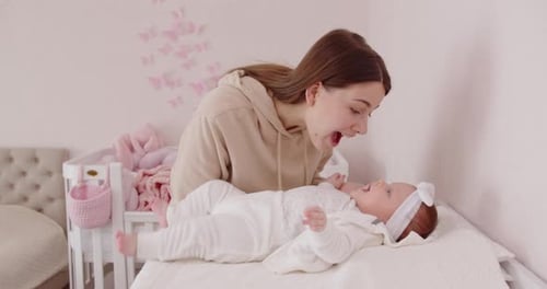 Loving Mother Interacting with Infant Daughter in Nursery