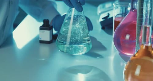 Zeitlupe des Labortechnikers beim Mischen von Chemikalien in einem Labor