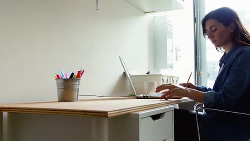 Woman Talking on the Phone at Desk