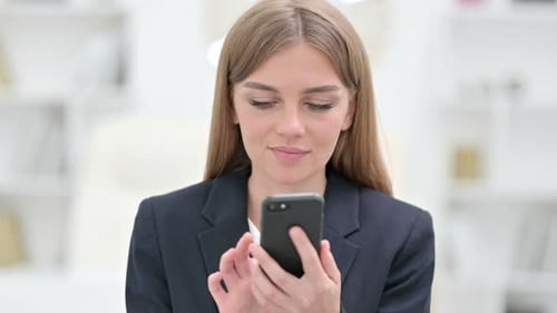 Young Woman Using Smartphone in Bright Office