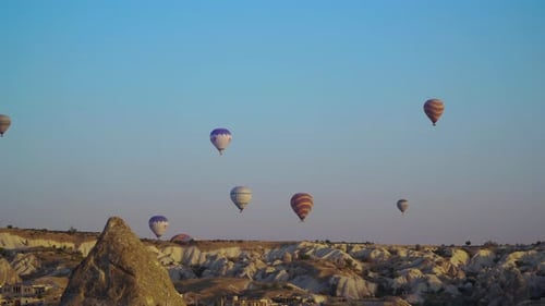 Hot Air Balloons Soaring Over Desert Landscape at Sunrise