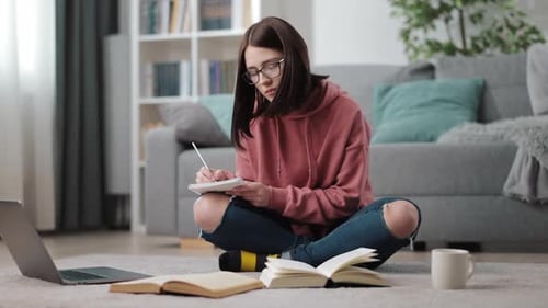 Student Studying with Books and Laptop at Home