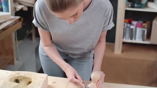 Woman Crafts a Carving in her Workshop