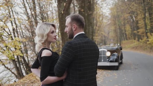 Lovely Couple Walking Under the Arms Foot to Foot in Autumn Park