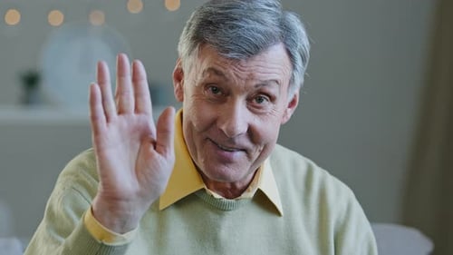 Senior Man Talking and Waving Indoors