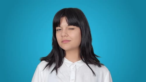 Smiling Woman Winks at the Camera on Blue