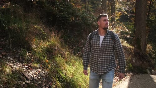 Man is Travelling Alone in Forest at Autumn Day