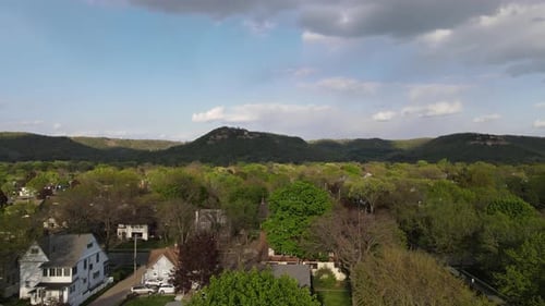 Überführung der Stadt im Mittleren Westen im Tal mit Bergen, die von Bäumen bedeckt sind, Schatten von Wolken geworfen.