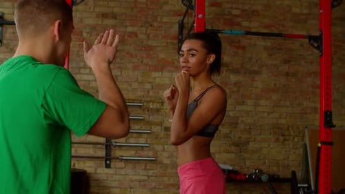 Woman Boxing with Trainer at Urban Gym