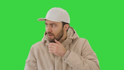 Man in Winter Outfit Walking and Coughing on a Green Screen, Chroma Key.