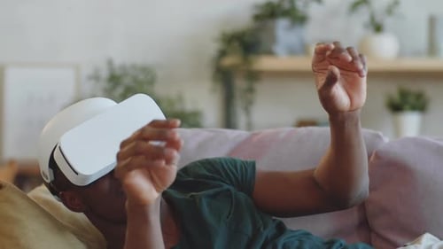 Man Wearing VR Headset on Couch Indoors