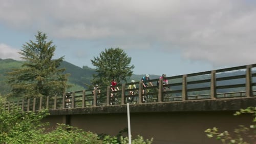 Group of cyclists on road ride over bridge. Fully released for commercial use.
