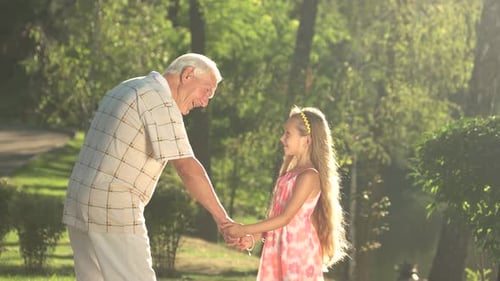 Grandfather and Granddaughter Holding Hands in Green Park