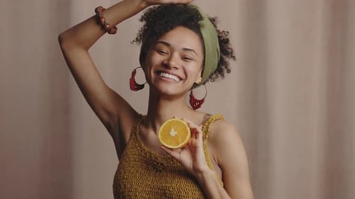 Cheerful Woman Posing with Sliced Oranges