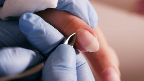 Manicurist is Cutting Cuticle with Professional Nail Tongs for Manicure