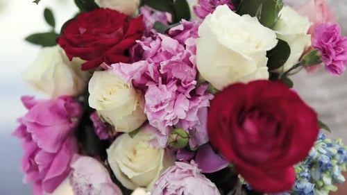 Close Up of Bride in Her Wedding Dress Holding Flower Bouquet of White, Red, and Pink in Her Hands O