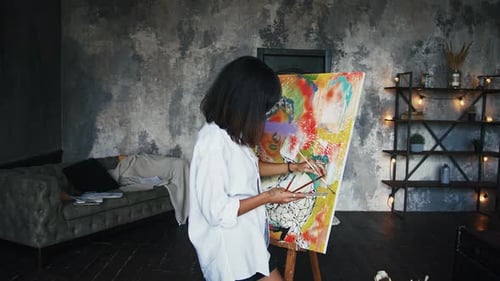 Woman Painting Colorful Abstract Art on Canvas Indoors