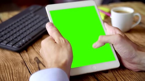 Hands Using Digital Tablet with Green Screen at Desk
