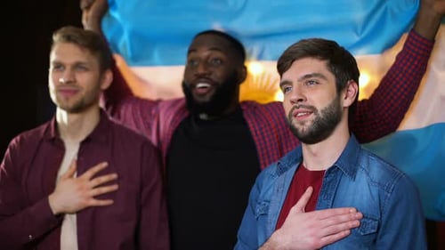 Three Men Cheering with National Flag in a Bar