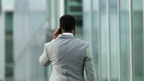 Back View of African American Businessman Talking on Smartphone