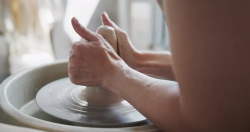 Une potière façonne un morceau d'argile sur la roue à poterie.