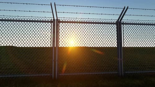 Animated Security Chain Link Fence with Barbed Wire at Sunset