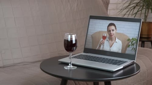 Woman Cheers Red Wine over Video Call