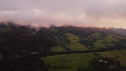Aerial view , Hilly rural landscape after a storm shrouded in clouds at dusk in the golden hour.