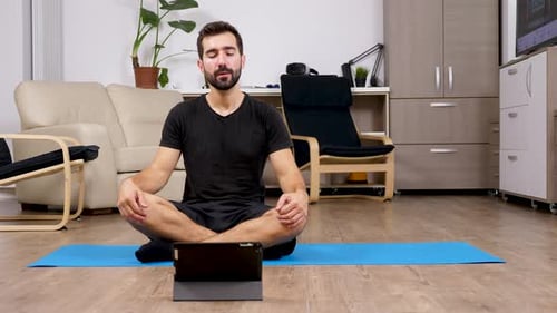 Man Practices Shoulder Rotation Yoga at Home