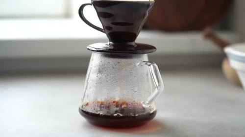 Coffee Drips Into Glass Carafe in Kitchen