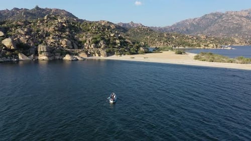 Rowboat Glides Across Tranquil Lake on Sunny Day