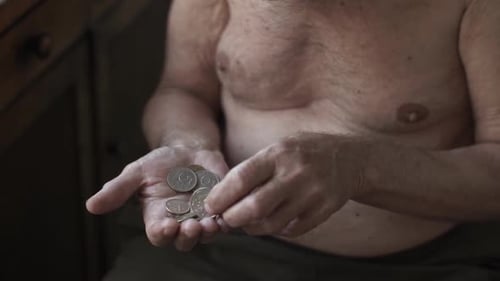Man counting coins in hand indoors