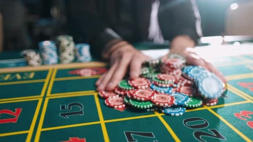 Casino, Gambling, Poker, People and Entertainment Concept - Close Up of Poker Player with Chips at