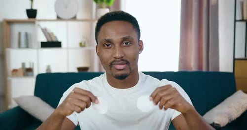 Young Man Holding Cotton Pads in Living Room
