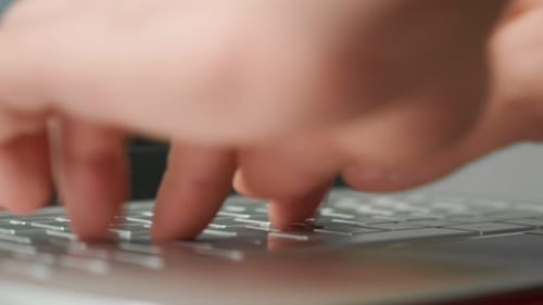 L'homme tape rapidement du texte sur le clavier d'un ordinateur portable