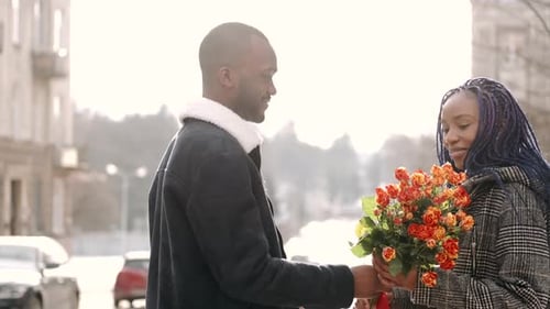 Young African American Couple with Flowers Dating in the City
