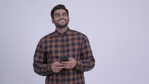 Young Adult Uses Smartphone, Looks Thoughtful