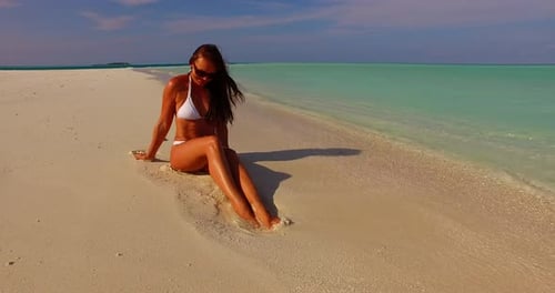 Pretty fun woman travelling by the sea on beach on paradise white sand and blue background