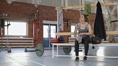 Female Boxer Drinking Water after Workout