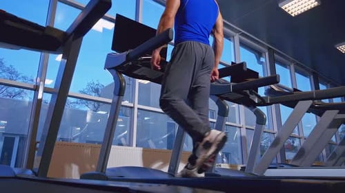 Adult Man Walking on Treadmill in Gym