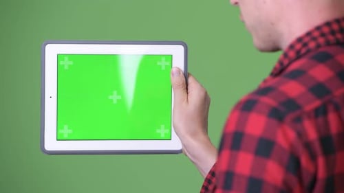 Young Scandinavian Businessman Using Digital Tablet Against Green Background