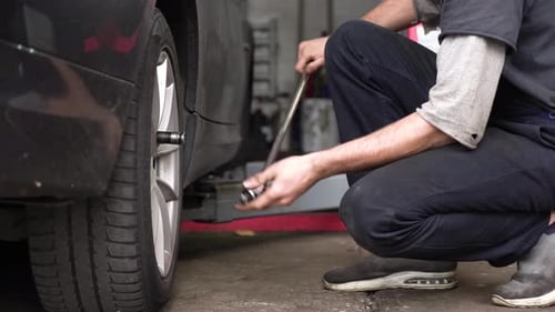 auto mechanic spins the wheel of the car. car workshop.