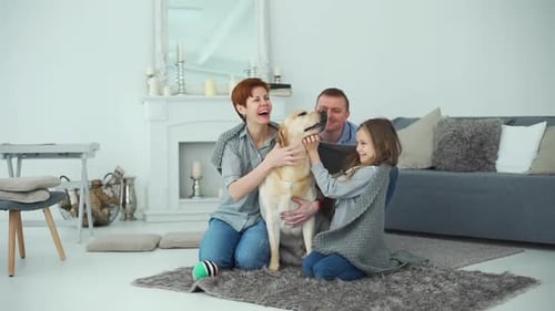 Happy Family Pets Their Dog at Home