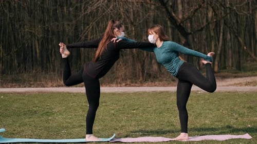 Two Women Practicing Synchronized Yoga Outside