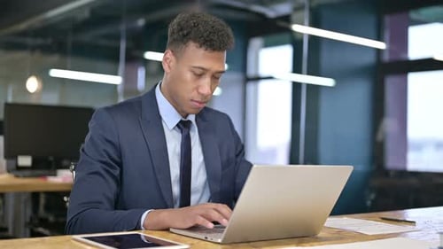 Professional Young Adult Working on Laptop in Office