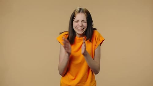Enthusiastic Woman Clapping and Cheering on Beige Background