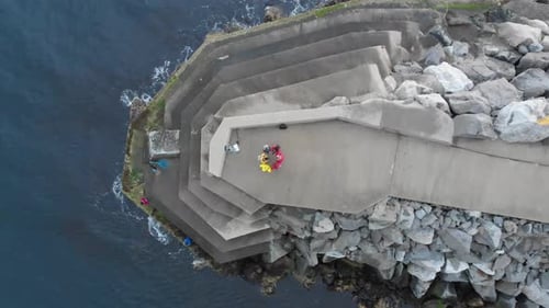 People forming circle on cliff building