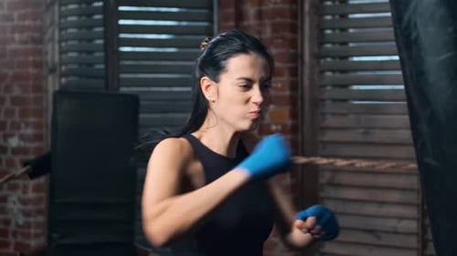 Woman Training Hard, Punching a Heavy Bag at Gym