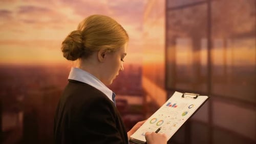 Business Woman Charts Data at Sunset