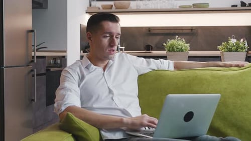 Man Working on Laptop at Home Feeling Stressed